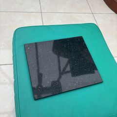 Two black granite chopping boards or heat boards