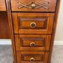 Crafted from stained hardwood with raised drawer panels, rounded pedestal edges, and an arched top mirror crown bordered by heavy metal or wood accent brackets. Nautical Rope Detailing: The upper accent panels on the mirror frame, the top left drawer, and Image 4