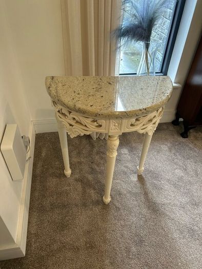 ornate half-moon console table with a granite top