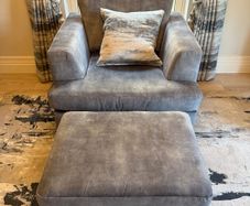 Grey fabric armchair with matching footstool