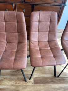 Four brown leather dining chairs