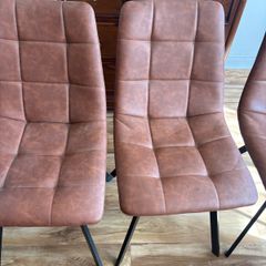 Four brown leather dining chairs