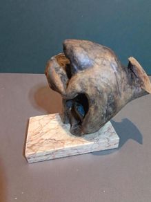 Free form bog oak statue on red marble