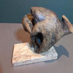 Free form bog oak statue on red marble