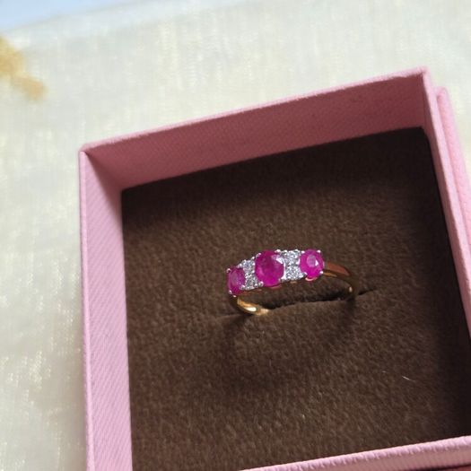 Beautiful yellow gold ring featuring three stunning rubies surrounded by sparkling cubic zirconia stones. Size M, in beautiful condition.