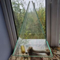 Glass ritual pyramid with bones and candle