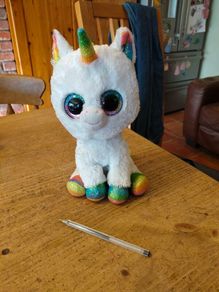 This is a Ty Beanie Boos Pixy the White Unicorn plush toy with large, glittery eyes