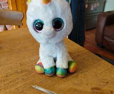 This is a Ty Beanie Boos Pixy the White Unicorn plush toy with large, glittery eyes