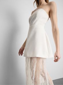 Strapless mini overlay maxi dress features a tailored bandeau top with a contrasting sheer floral lace skirt