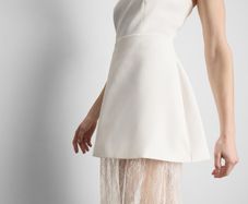 Strapless mini overlay maxi dress features a tailored bandeau top with a contrasting sheer floral lace skirt