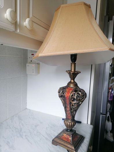 Vintage Tuscan style table lamp with gold-finish resin body with intricate scrollwork and reddish-orange mosaic crackle accents