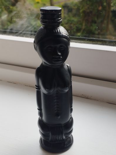 Vintage miniature "VUDU" bottle made of opaque black glass.