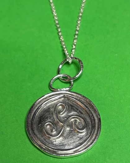 Sterling silver Triskele pendant with 18 inch chain.