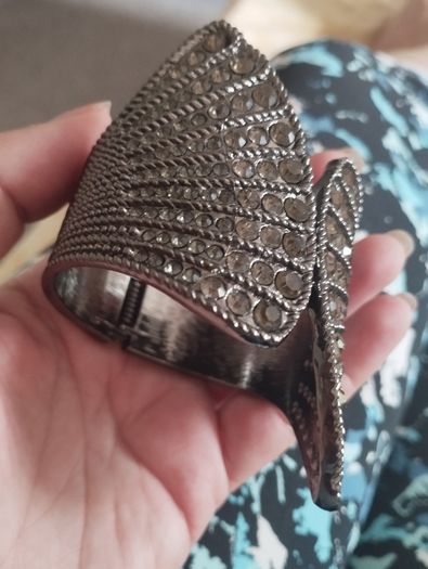 A striking wide bracelet encrusted with sparkling rhinestones.