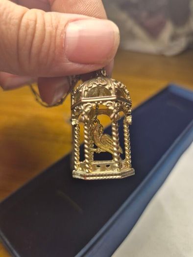 Vintage gilded bird cage with a bird pendant.