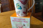Butterfly Shaped Handle Ceramic Mug, decorated with various colorful butterfly graphics. 3D ceramic butterfly molded directly onto the handle. New in Box.