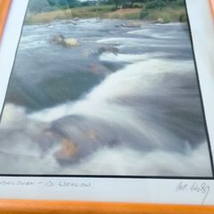 Framed Photograph art print depicting a rushing stream or waterfall, labeled -Glendalough - Co Wicklow- and hand-signed by the artist by Michael Walsh.