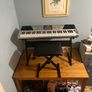 RockJam Electronic Keyboard Piano set up on a sturdy, matching heavy-duty Z-frame stand and an adjustable padded X-frame RockJam Keyboard Bench resting on a wooden surface. Image 4