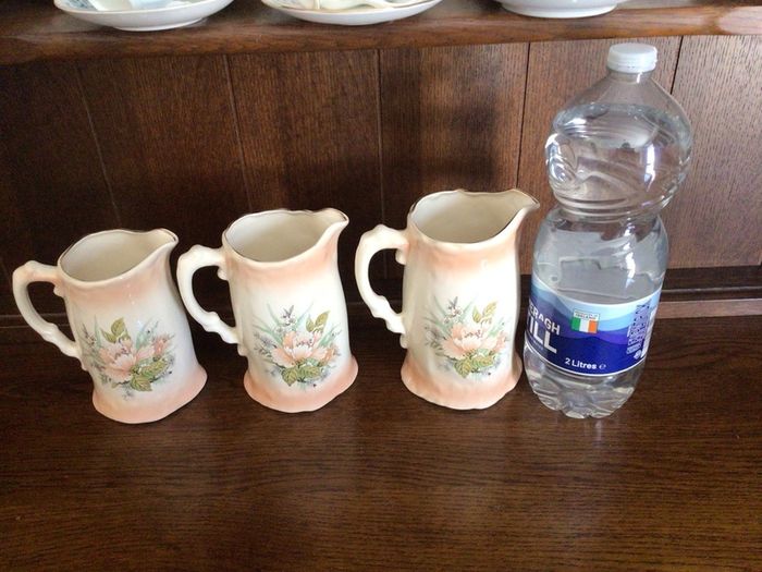 A set of 3 Large Peach Floral porcelain Graduating jugs