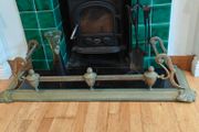 Art Nouveau orbed style cast brass hearth fender with a pair of companion orbed fire dogs