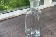 Tall heavy clear glass spirit decanter with large solid glass stopper.