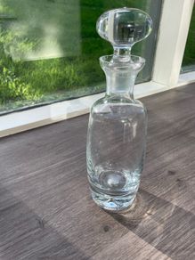 Tall heavy clear glass spirit decanter with large solid glass stopper.