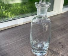 Tall heavy clear glass spirit decanter with large solid glass stopper.