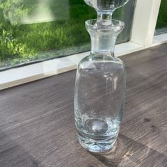 Tall heavy clear glass spirit decanter with large solid glass stopper.
