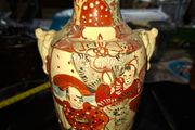 Japanese Satsuma vase featuring intricate hand painted designs of figures and patterns.  This type of earthenware pottery often dates to the Meiji period late 19th century or early 20th century