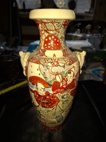 Japanese Satsuma vase featuring intricate hand painted designs of figures and patterns.  This type of earthenware pottery often dates to the Meiji period late 19th century or early 20th century