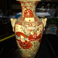 Japanese Satsuma vase featuring intricate hand painted designs of figures and patterns.  This type of earthenware pottery often dates to the Meiji period late 19th century or early 20th century