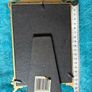 gold-toned metal 5x7 picture frame with decorative floral embellishments. Image 3