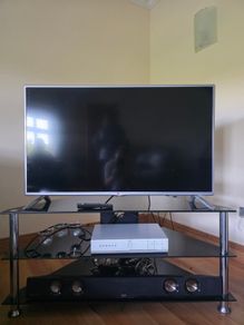 LG 42-inch Full HD Smart TV with a 3-tier black glass TV stand.