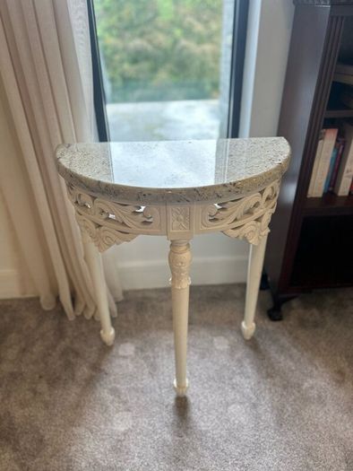 ornate half-moon console table with a granite top