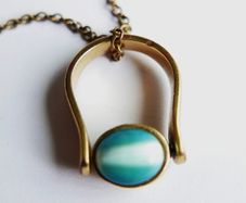 Vintage necklace features a polished, knocker-shaped pendant  gold plated, centered with an iridescent turquoise Spinning Fob