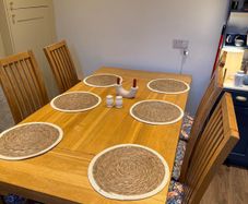 Solid oak dining table & 6 reupholstered dining chairs