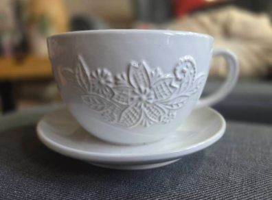 plant pot in the shape of a cup and saucer.