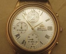 This is a gold-tone Seiko Vintage V657-8110 quartz chronograph watch featuring a cream dial with Roman numerals and three sub-dials