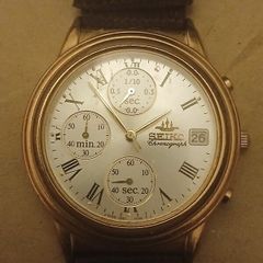 This is a gold-tone Seiko Vintage V657-8110 quartz chronograph watch featuring a cream dial with Roman numerals and three sub-dials