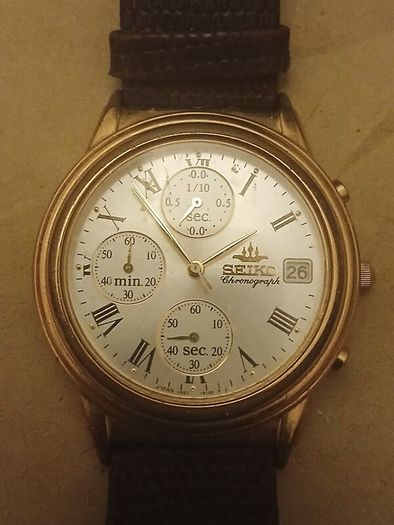 This is a gold-tone Seiko Vintage V657-8110 quartz chronograph watch featuring a cream dial with Roman numerals and three sub-dials