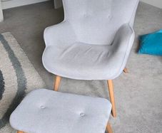 Scandinavian-style wingback armchair with a matching footstool