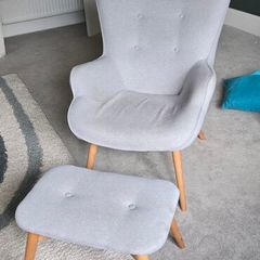 Scandinavian-style wingback armchair with a matching footstool