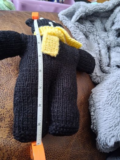 Hand knitted black teddy bear with yellow scarf