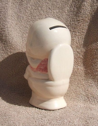 A vintage novelty money box in form of a young child sitting on a toilet (1930s to 1960s)