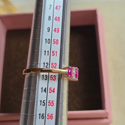 Beautiful yellow gold ring featuring three stunning rubies surrounded by sparkling cubic zirconia stones. Size M, in beautiful condition.