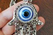 Hand with evil eye necklace and pendant