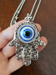 Hand with evil eye necklace and pendant