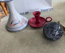 3 different itmes- 1- pottery modern design handmade candle holder 18.00 euro. 2-  red enamel candlestick holder and drip tray featuring a Considered by Helen James 12.00 euro. 3-  PAPERWEIGHT 15.00 euro