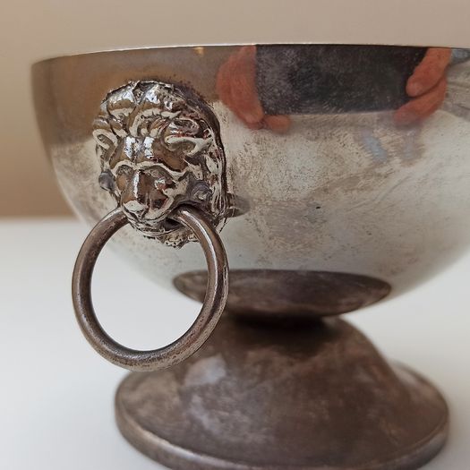 Small silver plated bowl with handles cast as lion's head holding a ring