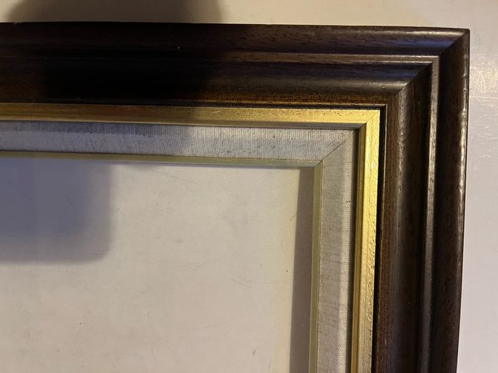 frame A rich dark-wood and gilt picture frame featuring a textured fabric mat liner.